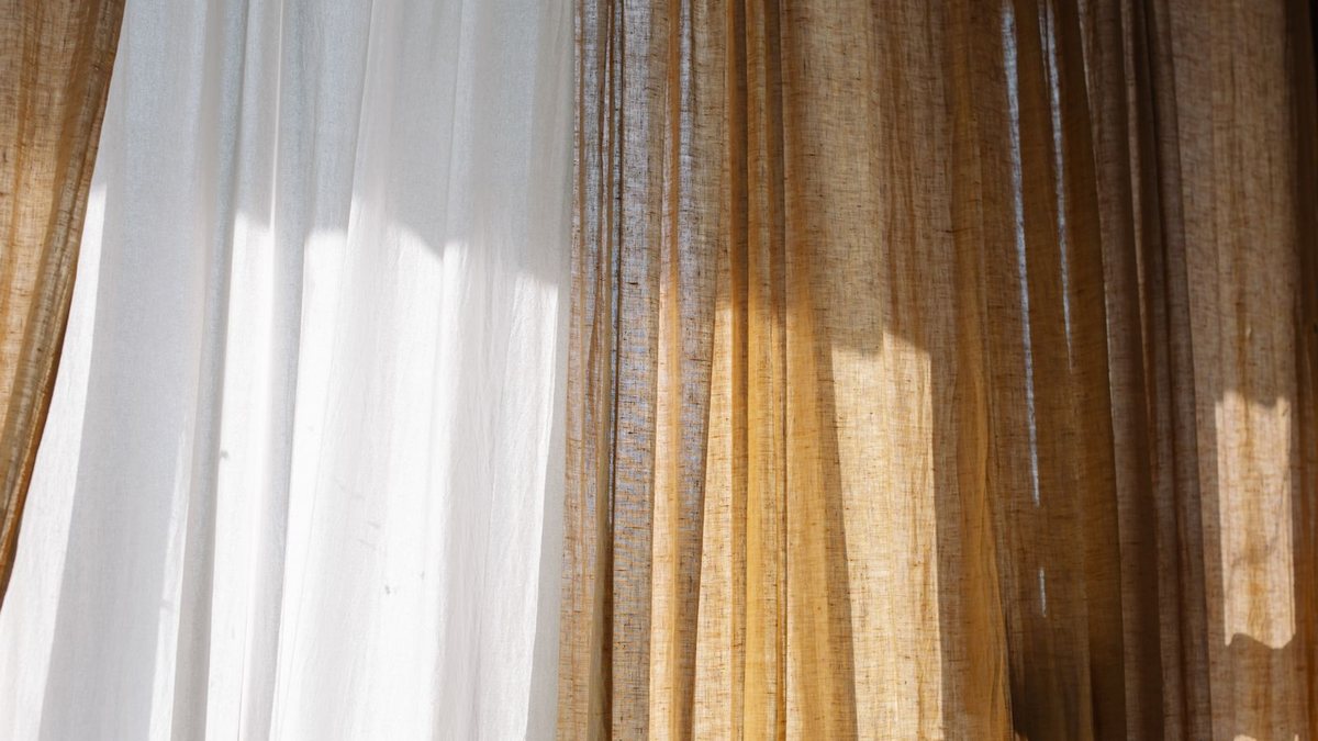 Sunlight through sheer white and natural linen curtains